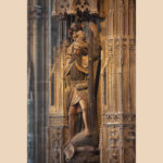 Zu sehen ist die Statue des Heiligen Christophorus. Er trägt reinen Baumstamm in der Hand und das Jesuskind auf der Schulter. Die Figur ist detailliert gestaltet, beide Personen blicken in den Kirchenraum unter ihnen.