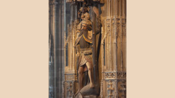 Zu sehen ist die Statue des Heiligen Christophorus. Er trägt reinen Baumstamm in der Hand und das Jesuskind auf der Schulter. Die Figur ist detailliert gestaltet, beide Personen blicken in den Kirchenraum unter ihnen.