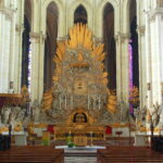 Zu sehen ist der Hochaltar der Kathedrale von Amiens. Die Große Figurengruppe die den Altarraum umringt lehnt sich zu einer großen steinernen Wolkenformation die den Hochaltar bildet. Alles ist in Gold und Stein gestaltet und wirkt fast, als ob die Wolken ein Portal in den Himmel öffnen würden. Copyright: Alf van Beem, CC0, via Wikimedia Commons
